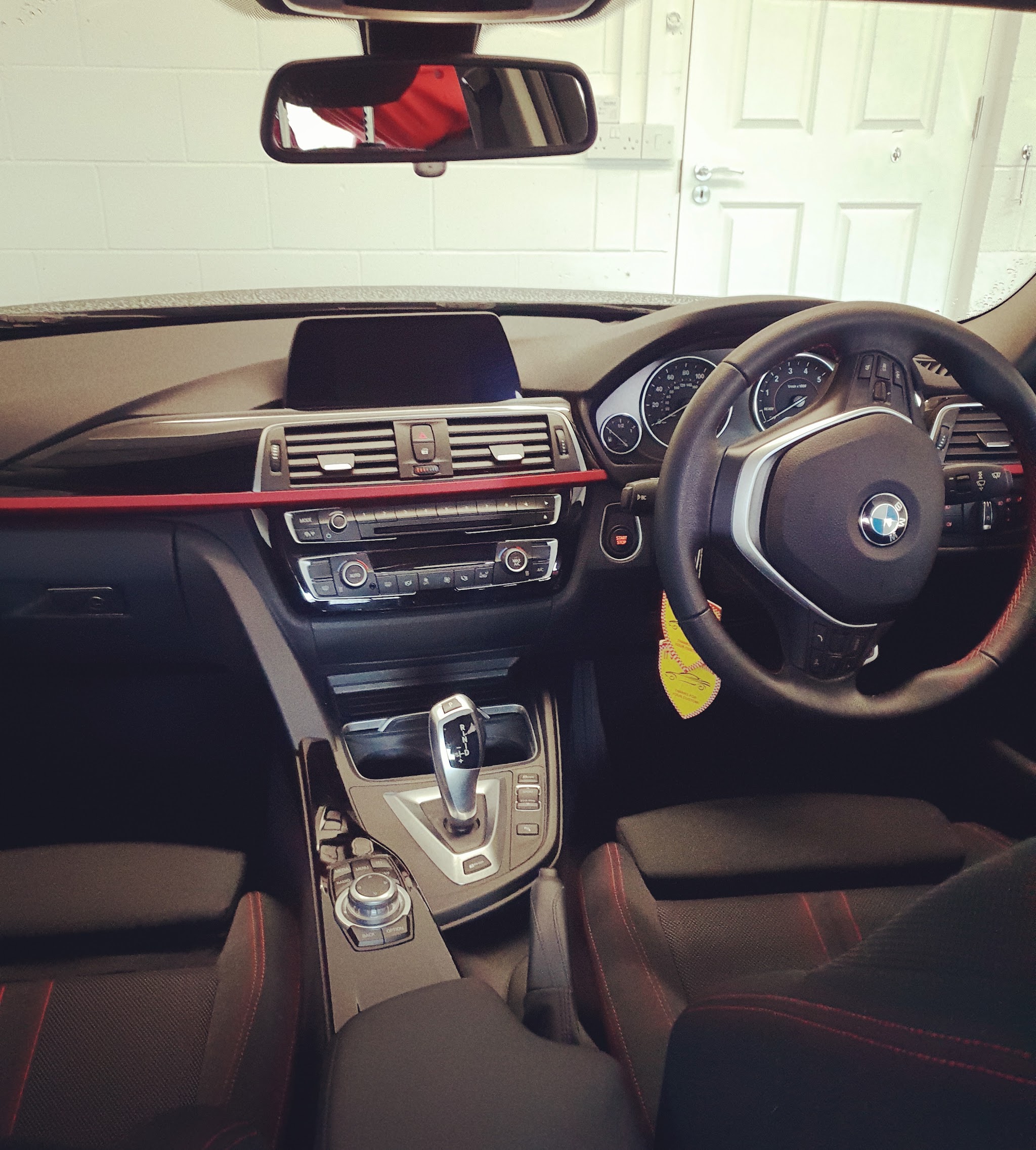 Cleaned car interior with black seats, dashboard and red trim